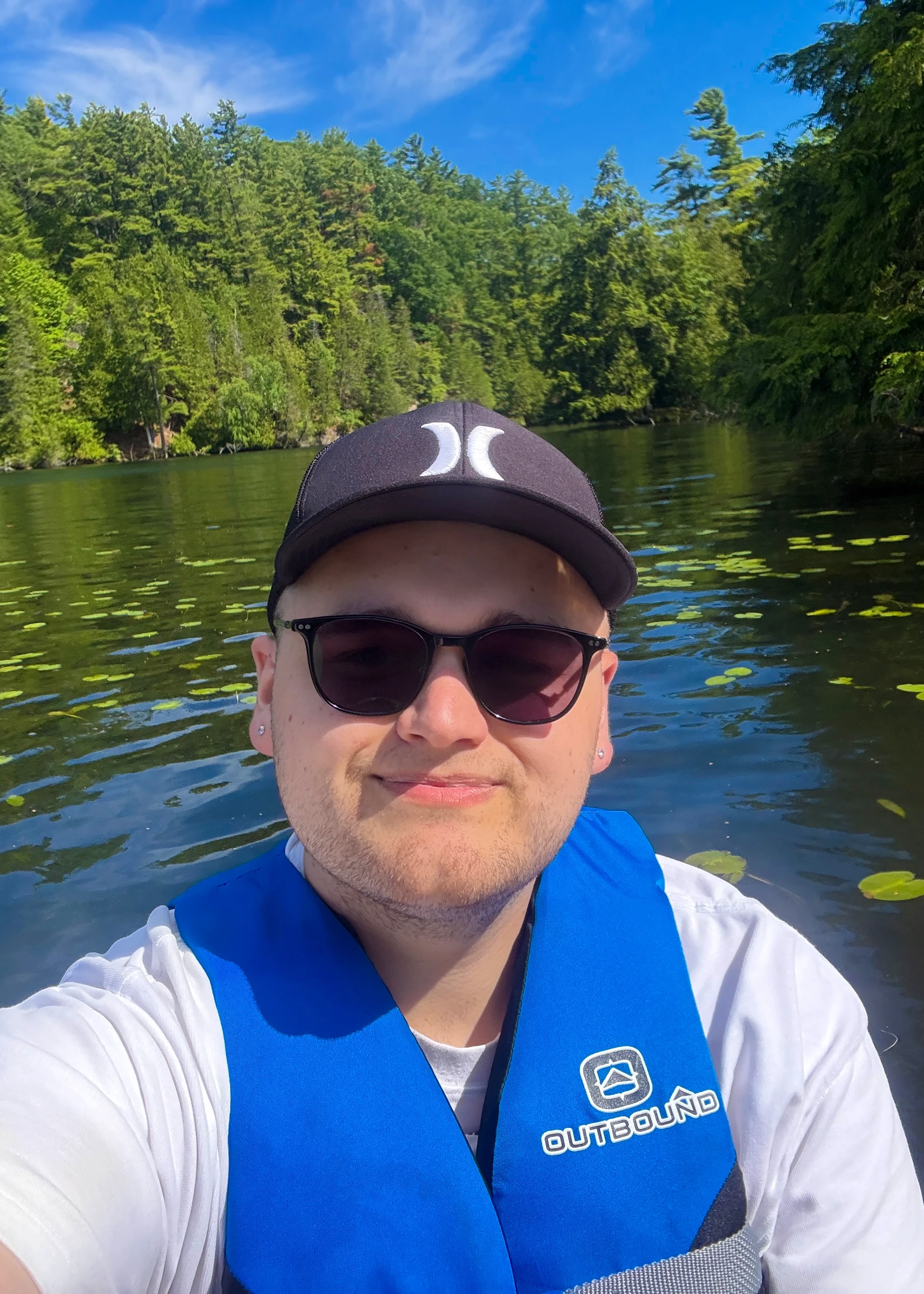 Selfie of Owen Denesuik wearing a life jacket while paddleboarding in Seeley’s Bay, Ontario.