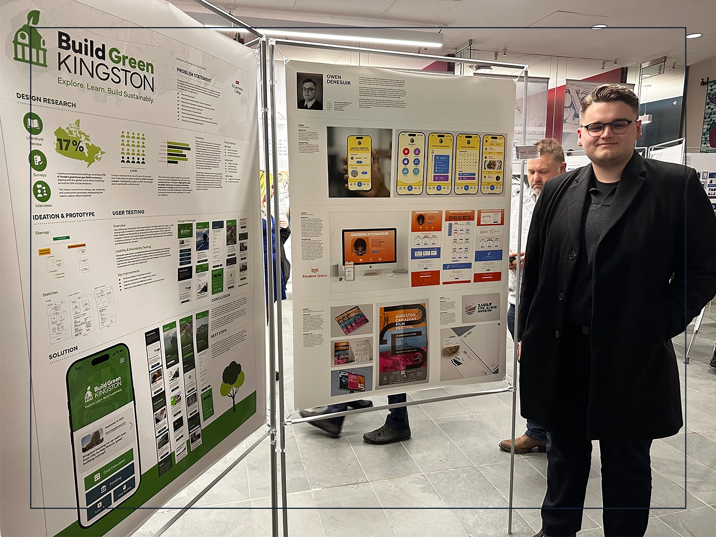 Owen Denesuik standing next to two poster with a capstone project for build green kingston and another showcasing work from over the years at college.